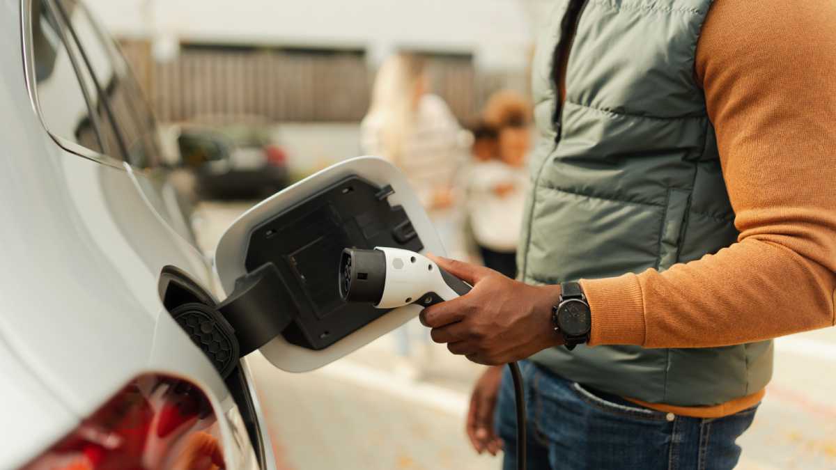 Hand plugging in an electric charge to an electric car