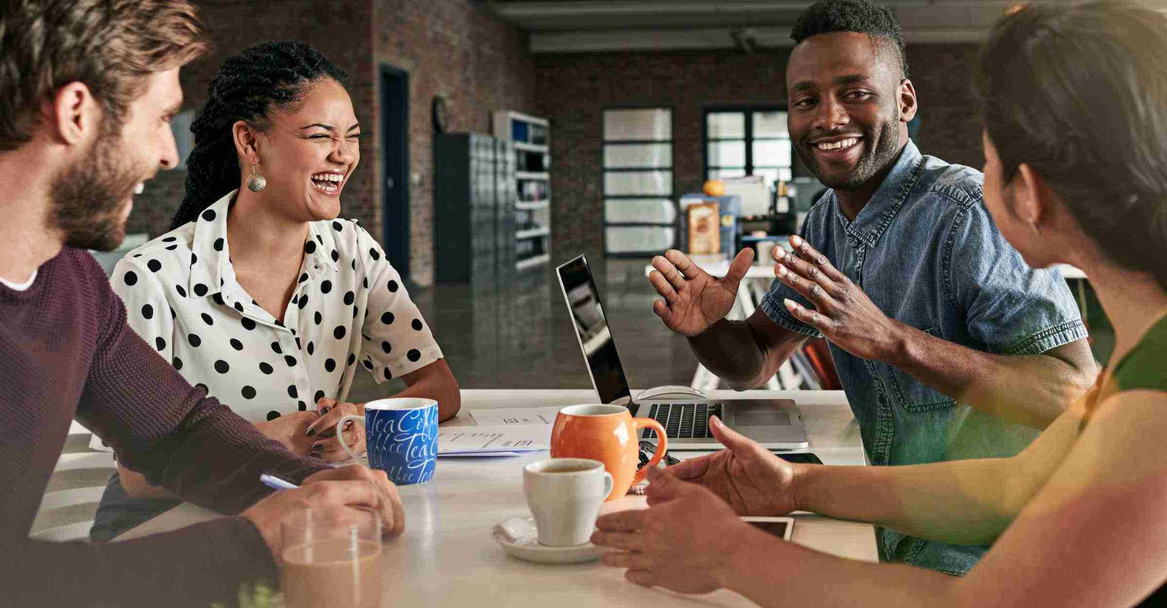 Group of four co workers sitting round a desk