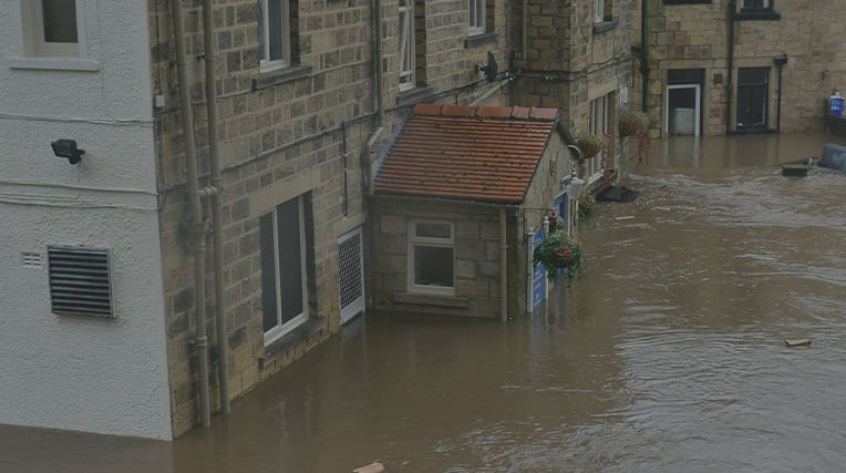 A street in England completely flooded with the water as high as the downstairs window of  terraced houses