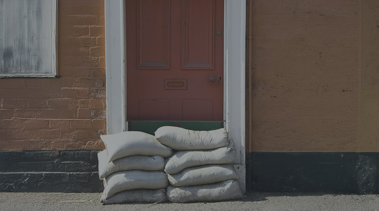 Sandbags outside a red door of a house